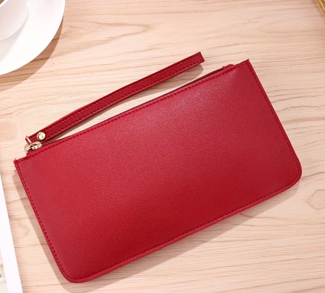 A Sleek Solid Colored Long Wallet with a soft Exterior It Features A Spacious Design A zip Closure And is Unlined Making it Ideal For Holding A mobil Phone Cash Coin's And Can Also Serve As a Small Gift