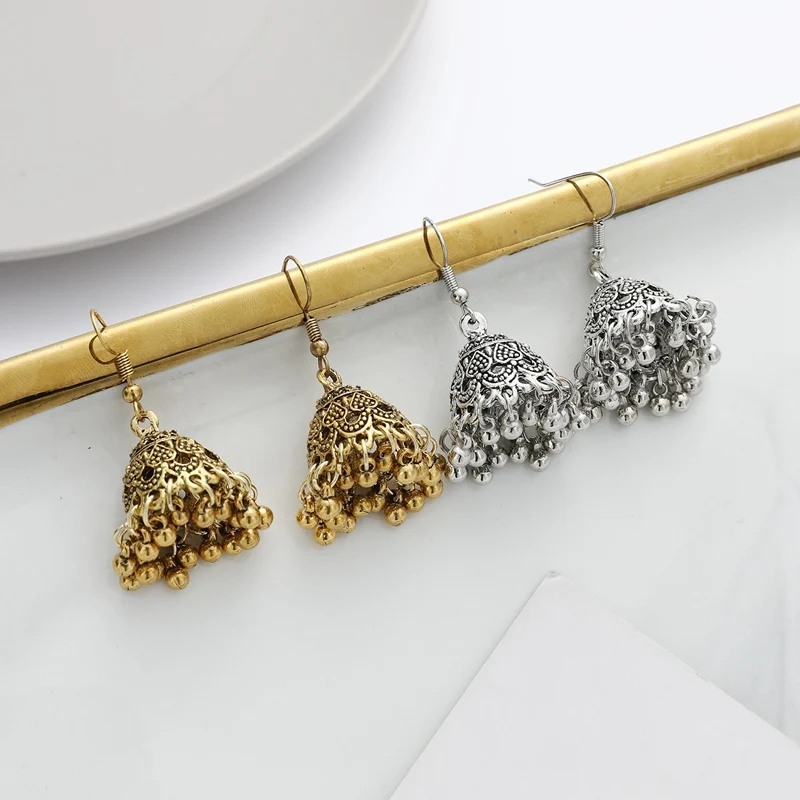 Stylish Egyptian-inspired earrings crafted with silver and gold oxidized finishes, featuring antique jhumka and baliyan designs. These lightweight eardrop earrings exhibit detailed craftsmanship with bell-shaped jhumkis and studs bringing a classic Woman