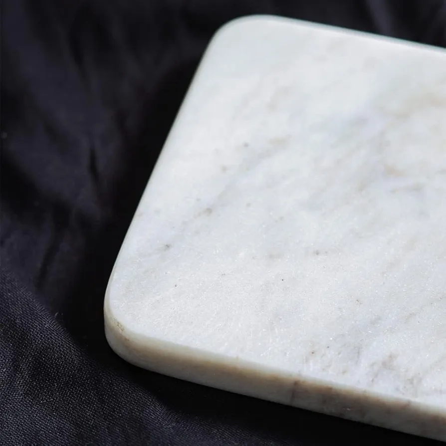 Elegant set of 4 white marble coasters, perfect for protecting surfaces with style. Each coaster has a smooth finish and natural stone texture, adding a touch of sophistication to any setting. 2